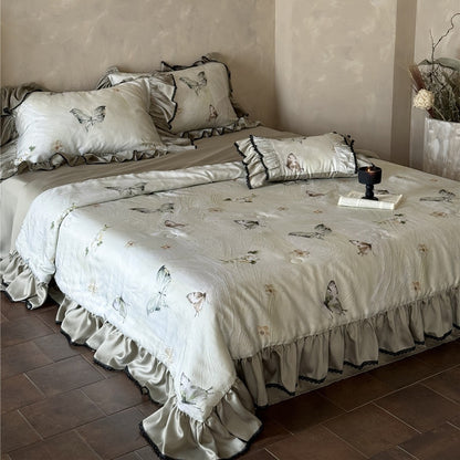 Close-up of butterfly print comforter corner with lace and ruffle detail