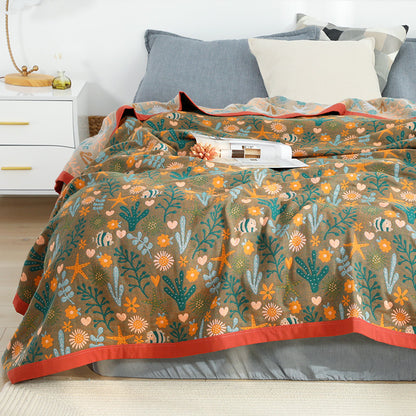 Soft and lightweight cotton gauze-style jacquard throw blanket in brown, featuring a playful marine life pattern of fish and starfish.