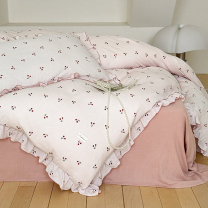 Full view of bed styled with a soft cotton gauze cherry print ruffle duvet cover set.
