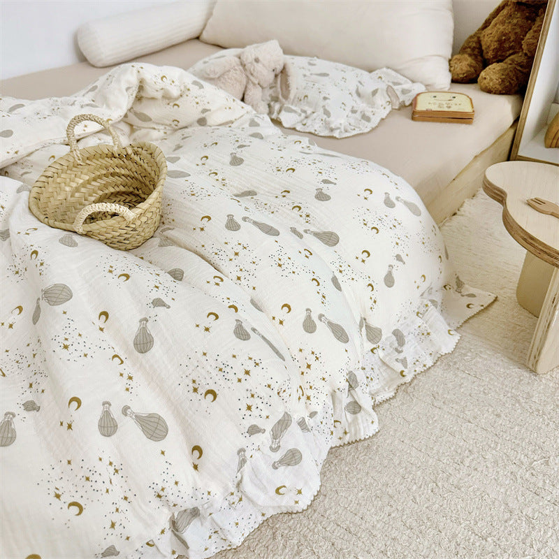 Whimsical kids' duvet cover with hot air balloon pattern and ruffle trim, styled in a neutral-toned child's bedroom.