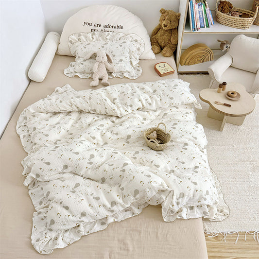 Kids bedding set with hot air balloon print, ruffle duvet cover, and pillow shams on a small bed.
