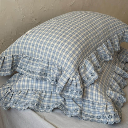 Detail shot of ruffled edge and plaid cotton muslin on pillowcase