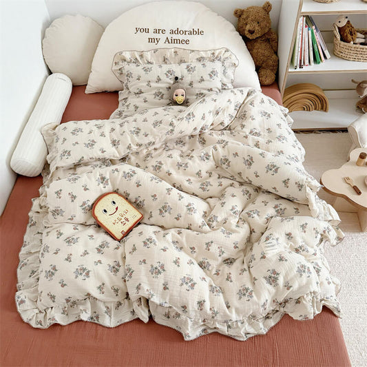 A full-bed shot of a duvet cover with flowers and a matching pillow, arranged on a rust bedsheet. 