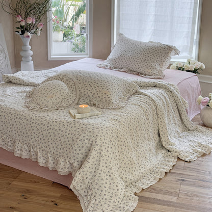 Full bed styled with romantic floral comforter and neutral surroundings for soft ambiance
