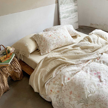 Flat-lay view of reversible floral bedding – light pink solid side revealed