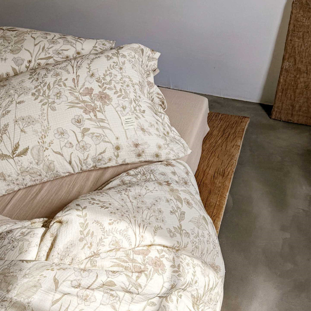 Side view of reversible floral cotton bedding – solid taupe and printed layers
