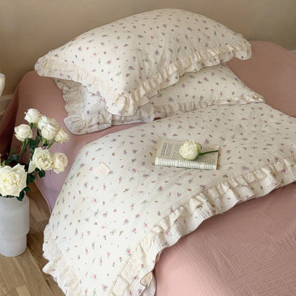 Romantic floral cotton comforter with ruffled edges styled in vintage bedroom