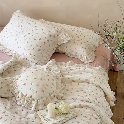 Soft floral comforter with delicate ruffled edges on textured bedding