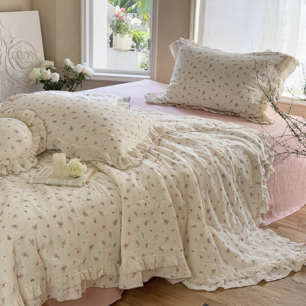 Romantic floral comforter with lace ruffles styled on vintage bed