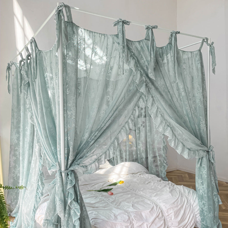 Light blue floral lace ruffle canopy curtains on white four-poster bed with white bedding and tulips