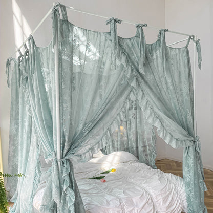 Light blue floral lace ruffle canopy curtains on white four-poster bed with white bedding and tulips