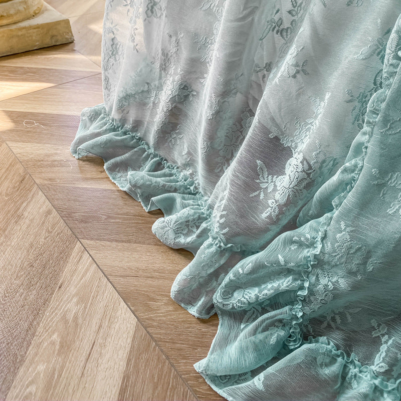 Close-up of light blue floral lace ruffle curtains on wooden floor, elegant sheer fabric detail