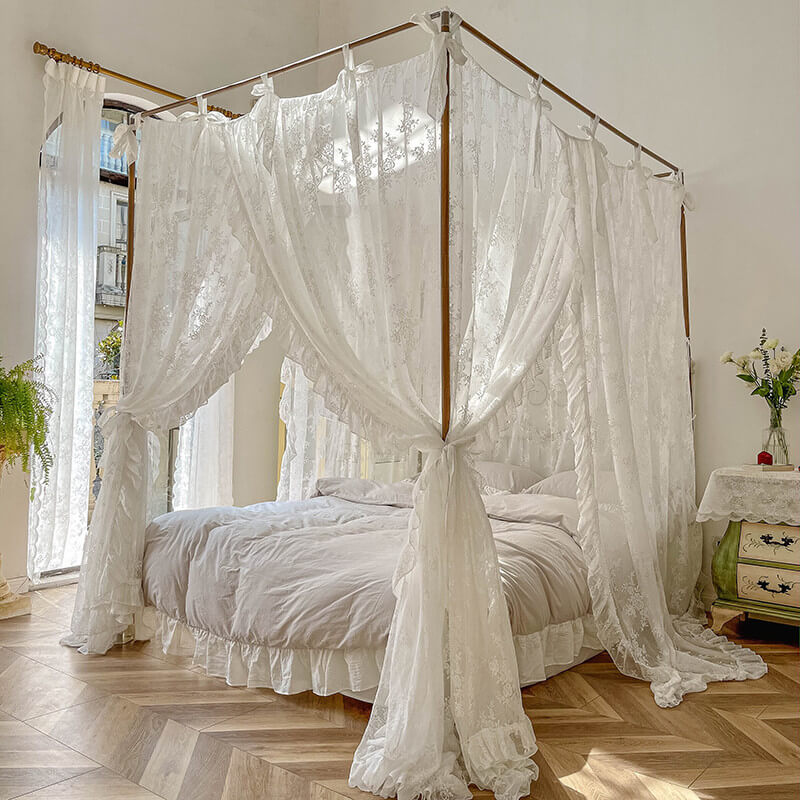Elegant 4-poster bed with floral lace ruffle canopy curtains in bright bedroom with wooden floor