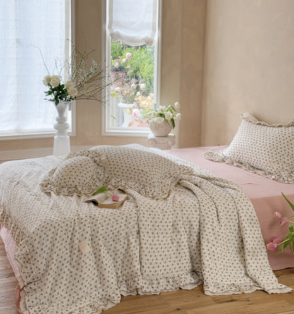 Lightweight pink rosebud comforter on bed in sunny room