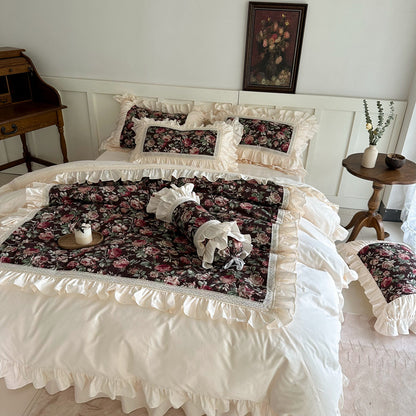 Full view of dark floral cotton bedding set with ruffled edges