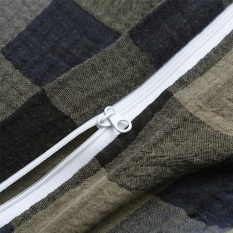 Close-up of zipper on army green plaid duvet
