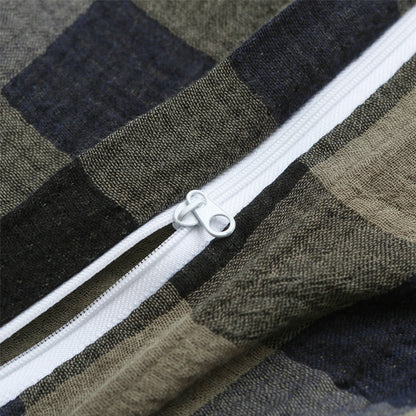 Close-up of zipper on army green plaid duvet