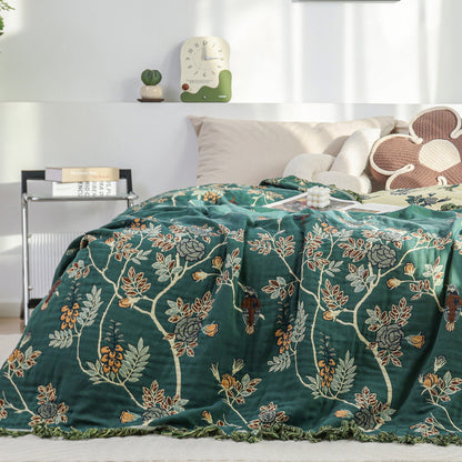 Reversible cotton jacquard blanket with botanical design on bed