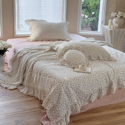 Ruffled cotton comforter layered with book and candle, perfect for a peaceful reading nook