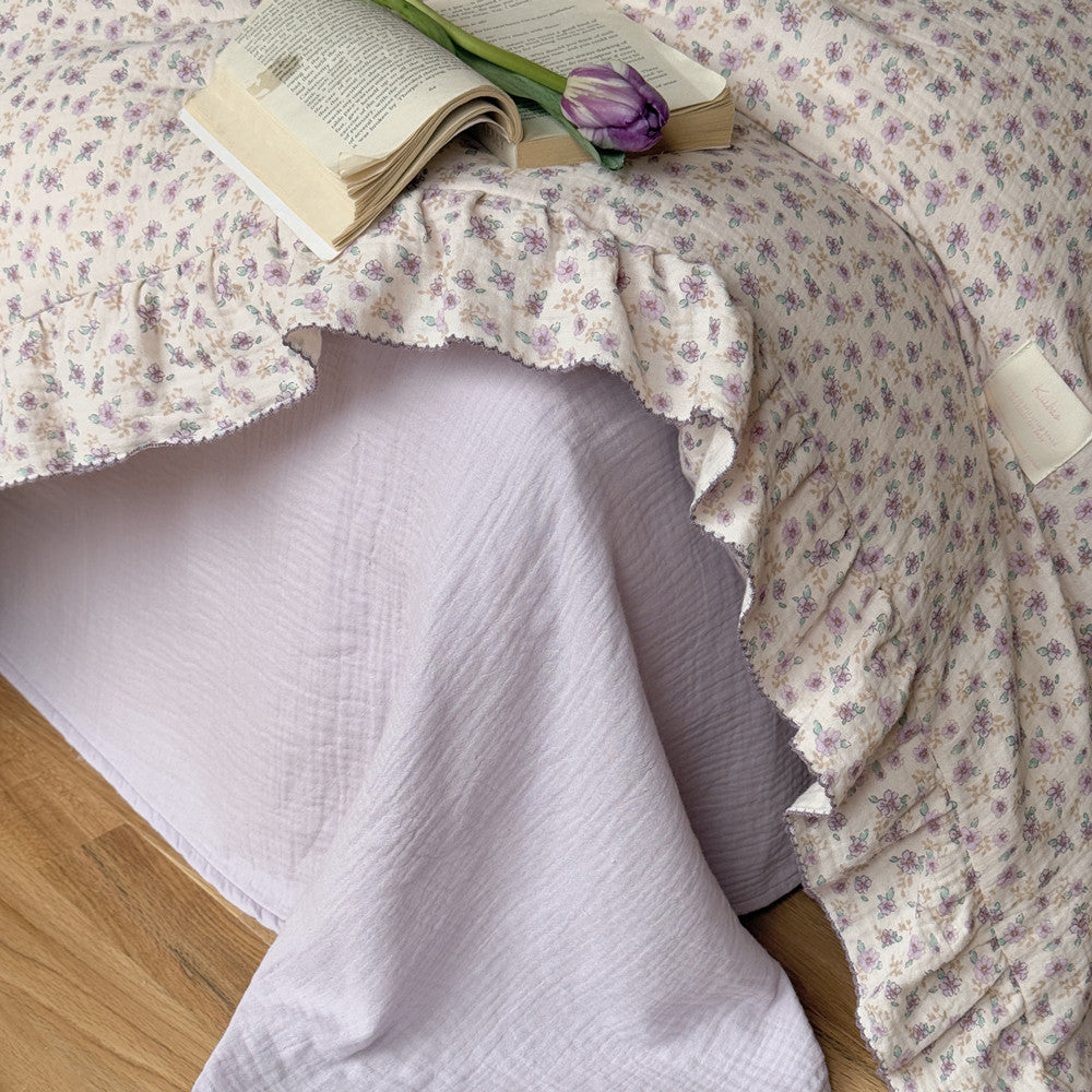 Lavender floral gauze bedding with flat sheet shown, highlighting layering and softness