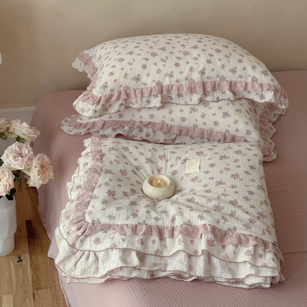 Rose floral comforter with ruffle trim displayed in cozy natural light