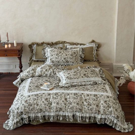 Vintage floral bedding set styled on a bed with olive fabric, ruffled edges, ivory lace trim, and French cottage bedroom decor