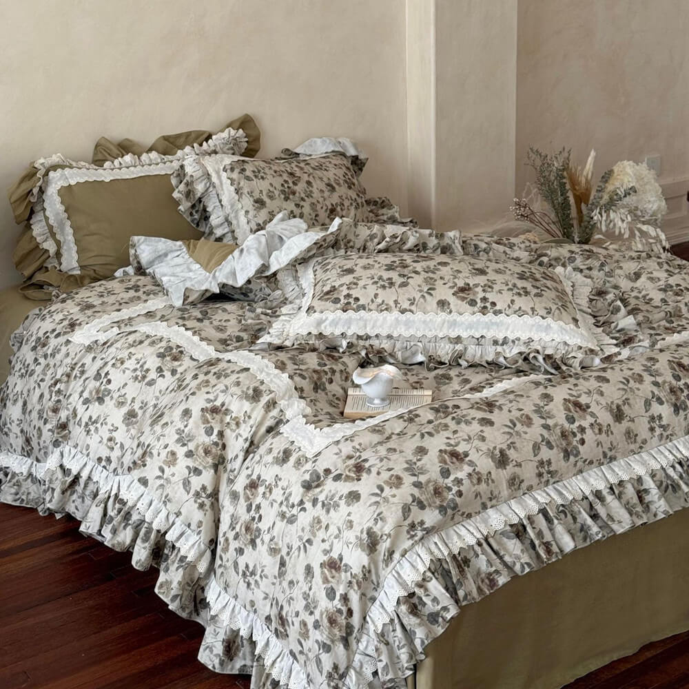 French cottage floral bedding set with olive solid fabric, faded floral print, ruffled trim, and ivory lace details in a cozy bedroom