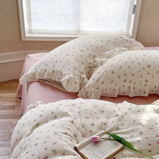 Pink floral cotton muslin duvet cover set with ruffles for a cozy girl's bedroom.