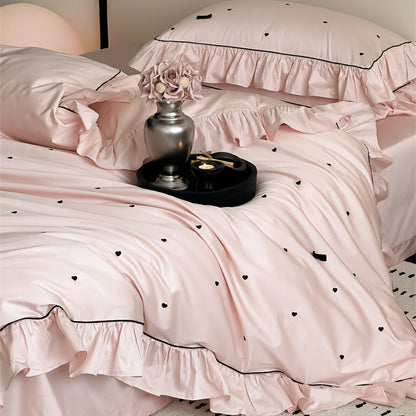 Side view of pink bedding set showing ruffles and embroidery detail