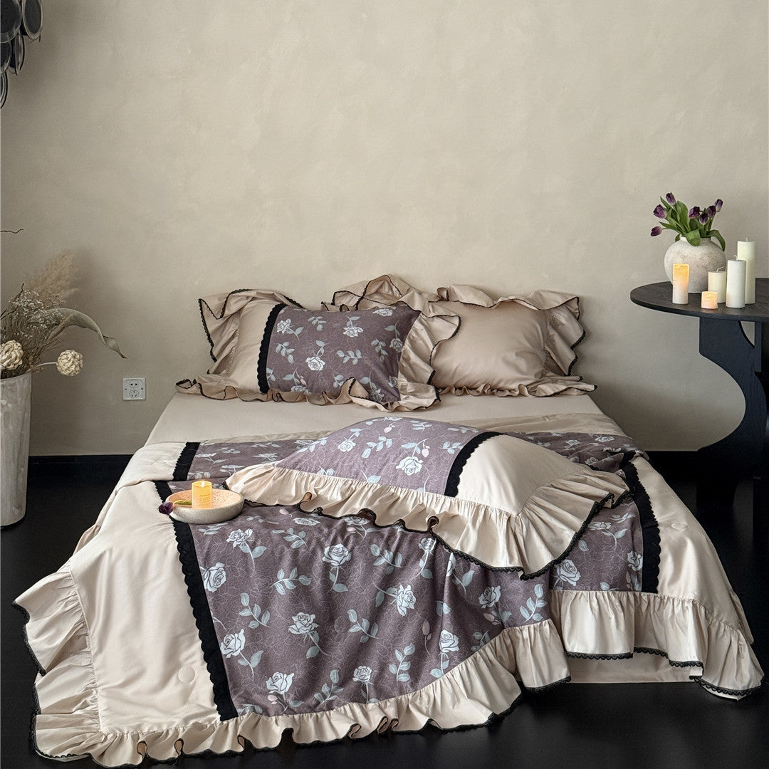 Full view of dusty mauve TENCEL rose bedding set with pillows and candles