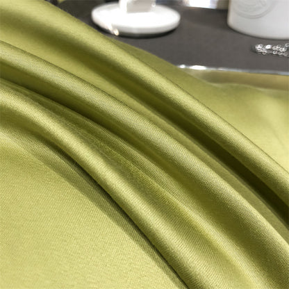 Silky green Tencel Lyocell pillowcase on a bed, soft sustainable bedding from StuffedHome