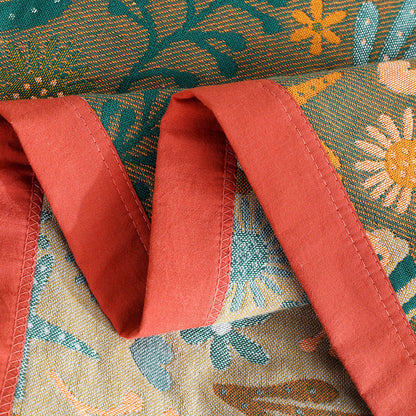 Detailed view of the red stitched border and high-density cotton weave of the ocean themed reversible jacquard throw blanket.